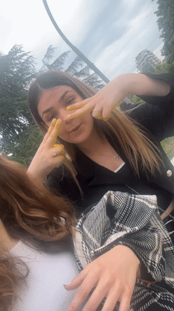 Young women apply yellow paint during riverside photo session