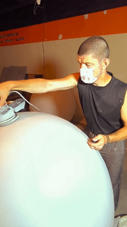 Sanding a large white sphere in Karaganda, Kazakhstan