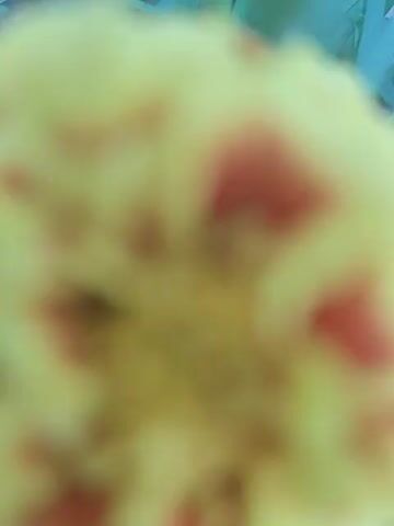 The video shows a close-up view of a marigold plant with several yellow and red flowers. The camera moves slowly, revealing different angles of the flowers and their green, feathery leaves. The plant is growing outdoors, surrounded by grass and soil. The lighting is natural, suggesting it is daytime.