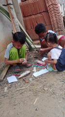 Woodworking and kids hanging out at an outdoor site in Indonesia