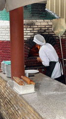 Chef works pizza oven, tourists visit tropical Karon street