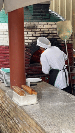 Chef works pizza oven, tourists visit tropical Karon street