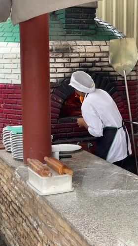 Chef works pizza oven, tourists visit tropical Karon street