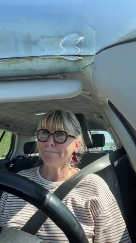 Woman drives through Veauche with music playing in worn car