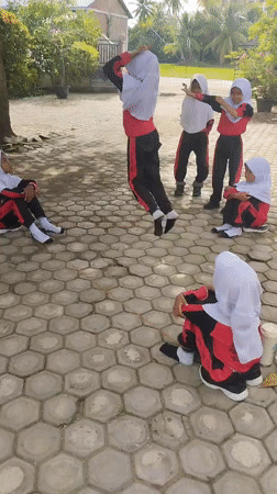 Schoolyard game in progress on a hexagonal paved courtyard