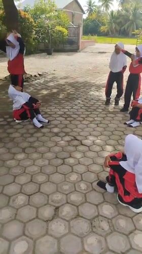 Schoolyard game in progress on a hexagonal paved courtyard