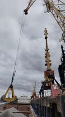 Cargo cranes operate at Rybinsk harbor under cloudy skies