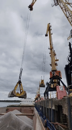 Cargo cranes operate at Rybinsk harbor under cloudy skies