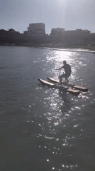 Busy coastal pier, cliff views, and boat activity on a sunny afternoon