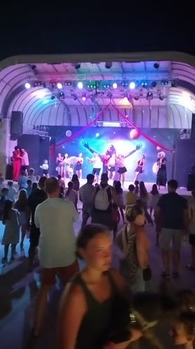 Nighttime outdoor stage show in Caorle with cosmic backdrop