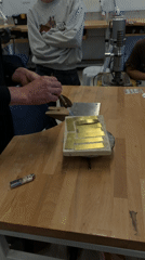 Metalworker heats brass pieces with torch in Jerusalem workshop