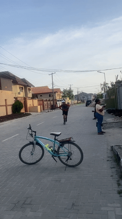 Roller skater performs bicycle jumps on residential street in Lekki