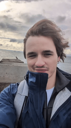 Man films selfies at Odesa pier during early morning