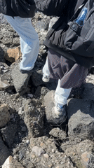Two people traverse rocky debris in Nor Artik, Armenia