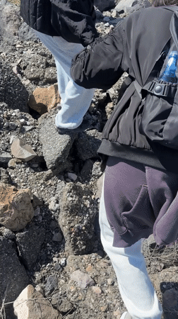 Two people traverse rocky debris in Nor Artik, Armenia