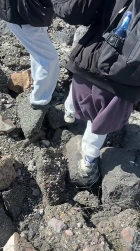 Two people traverse rocky debris in Nor Artik, Armenia