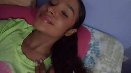 Woman makes playful expressions on bed in Venezuela