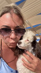 Woman documents lazy beach day with poodle in Anapa