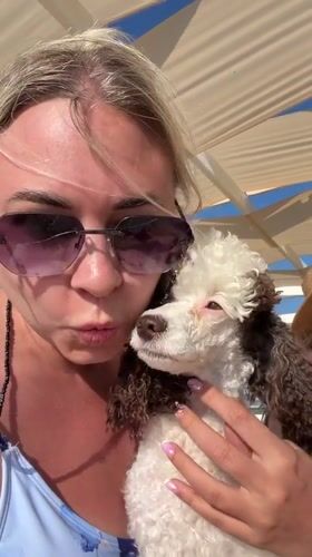 Woman documents lazy beach day with poodle in Anapa