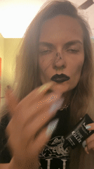 Woman applies makeup with gothic styling in Cape Coral