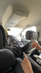 Back seat view of a gesturing driver in Leudelange