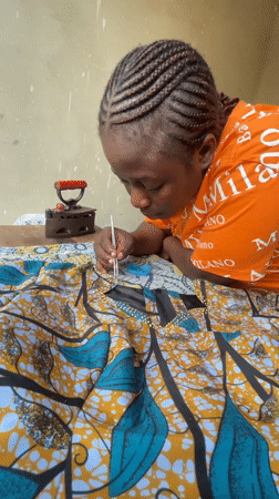 Pressing colorful fabric with a vintage iron in Akwanga