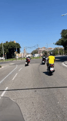 Scooters rolling through sunny Barcelona streets, mid-morning.
