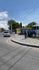 Pedestrian walks sidewalk in Gyumri amid parked vehicles