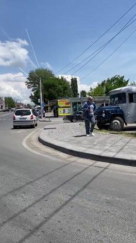 Pedestrian walks sidewalk in Gyumri amid parked vehicles