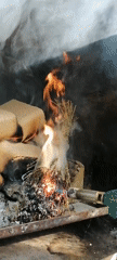 Person lights fire with gas torch in contained space