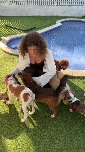 Woman plays with multiple dogs in Kediri backyard