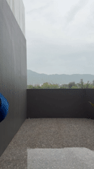 Woman observed on rainy balcony in Thai resort town