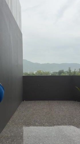 Woman observed on rainy balcony in Thai resort town