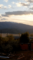 Sunset time-lapse captured over snow-capped mountains from urban viewpoint
