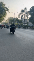 Rush-hour motorcycle traffic on a busy road in Gelam, Indonesia