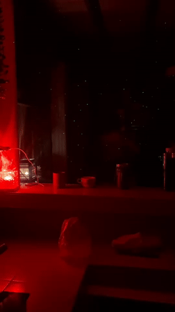 Dancing gathering captured in red-lit room in Baan Chaloklum