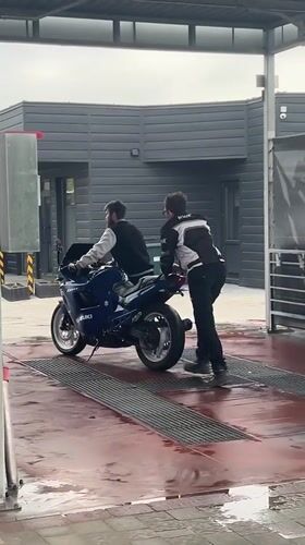 Motorcycle maintenance and washing documented in Horodok, Ukraine
