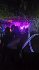 Outdoor night party with colorful lights and dancing