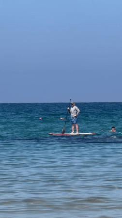 Man paddleboards in Tel Aviv waters Saturday morning