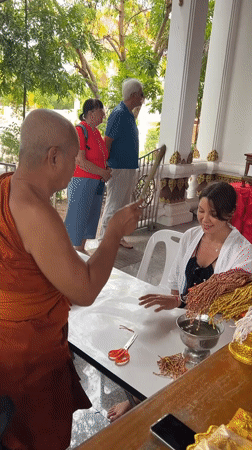 Woman receives traditional Buddhist blessings at Thai temples