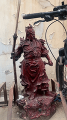 Red Chinese warrior statue with dragon motifs observed outdoors