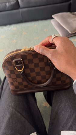 Person Opens Louis Vuitton Handbag in London