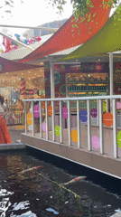 Shoppers enjoy candy-themed outdoor mall with koi pond, decorations