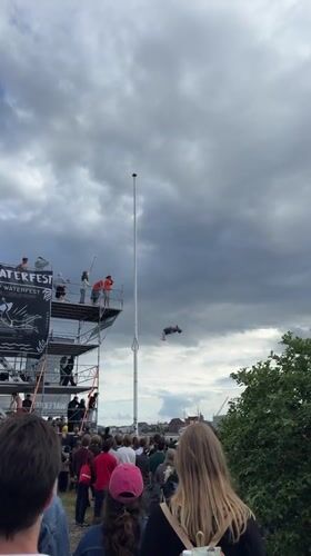 Diver performs aerial stunts from tall platform in Copenhagen