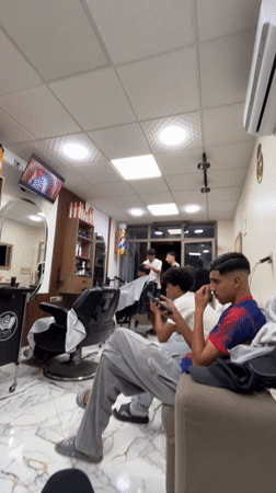 Young men wait with phones at Safi barbershop