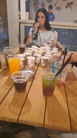 Woman at table with drinks in Kuşadası venue