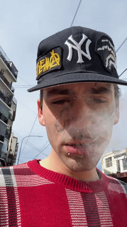 Tattooed youth smoking outdoors in Buenos Aires