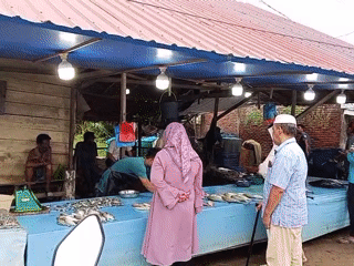 Fish vendor prepares fresh catch at Lhokseumawe market