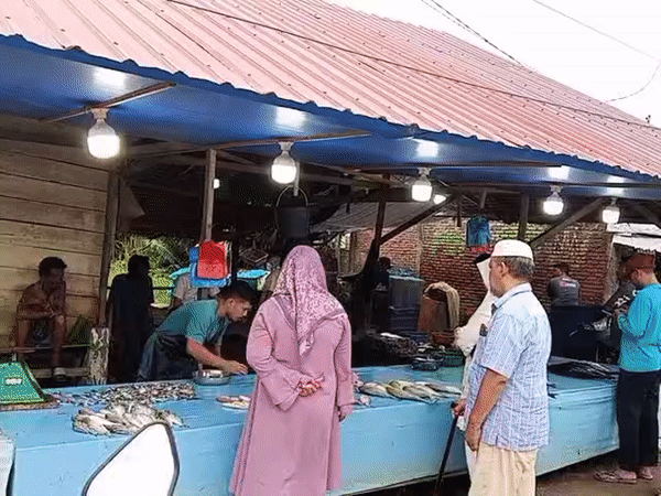Fish vendor prepares fresh catch at Lhokseumawe market