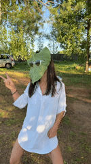 Leaf held over face in a Russian wooded park